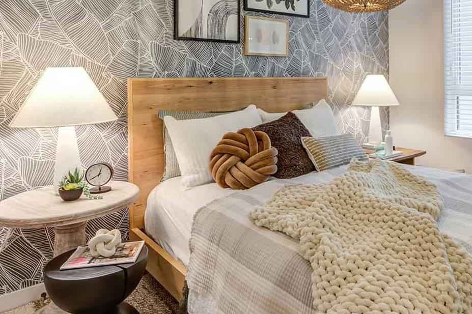 Stylish bedroom decor with earthy tones, including a wood bedframe, wall decor, nightstands, and lamps