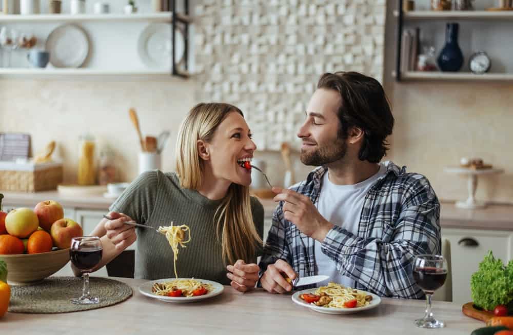 woman and man having dinner in their kitchen